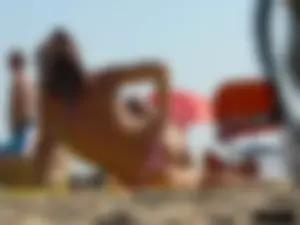 Topless tattooed lady at the beach with a nice ass in pink thong bikini