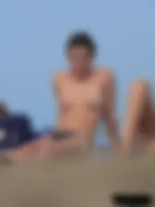 Sexy babe with a nice body topless and in a thong on the beach