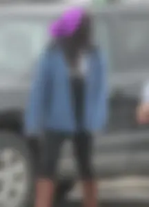 A cute brunette in leggings boots and hat