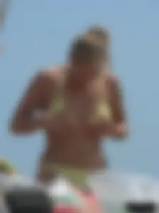 Sexy blonde on the beach in a yellow thong bikini