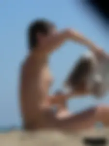 Topless beach milf looking sexy in a tiny g-string bikini