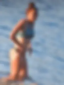 Sexy beach girl in a Nike sports bra and black bikini bottom