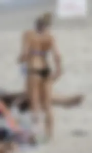 Blonde beach babe with a nice ass in black and blue bikini