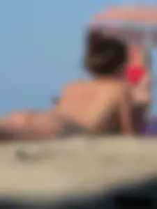 Sexy babe with a nice body topless and in a thong on the beach