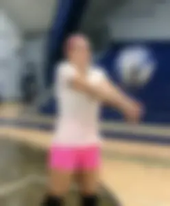 Bunch of cute college girls in bright pink shorts playing volleyball