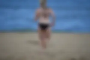 Chunky blonde in a black bikini on the beach