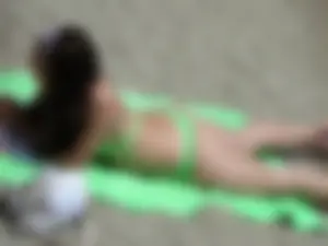 Sexy girl on the beach in her green thong bikini
