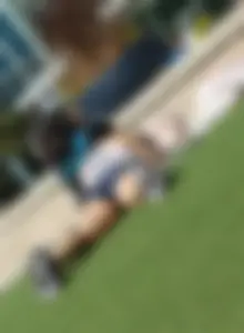 Hot stocky girl in mini-shorts chilling on the grass with widely spread legs
