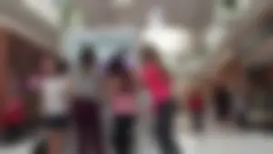 Little blonde teen in grey leggings at the mall with her friends