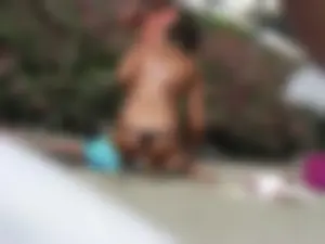 Sexy girl on the beach getting some sun in a little black thong bikini