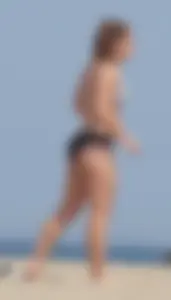 Sexy blonde girl on the beach in a bikini with nice legs, ass and stomach
