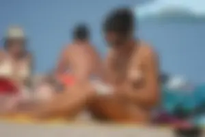2 topless girls at the beach in thongs