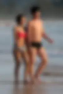 Cute Asian in bikini on the beach with her boyfriend