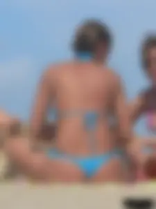 Sexy lady on the beach in a blue thong bikini