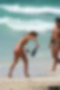Topless girl in a tiny thong on the beach playing paddle ball