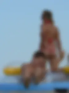 Sexy mom and daughter in red thongs at the beach