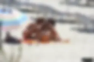 Topless milf and her topless daughter on the beach