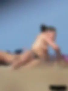 Sexy babe with a nice body topless and in a thong on the beach