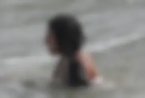 Brunette bikini girl on the beach and surfing in her bikini