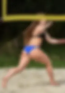 Cute girl playing volleyball in her little bikini