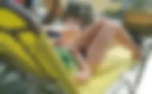 Young skinny candid girl laying on a sunbed, hot slim legs