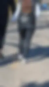 A beautiful little brunette walking in the park. tight black leggings