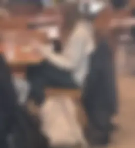 Teen wearing tight sitting with crossed legs in a canteen creepshot