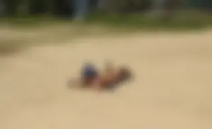 Sexy girl getting some sun laying on the beach in thong bikini