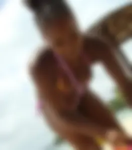 Sexy black babe in various bikinis on the beach while on vacation