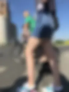 Cute Girl in a Short Denim Skirt Walking on a Street And Waiting on a Crosswalk Gallery