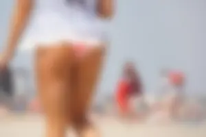 Trio of girls in bikinis on the beach and one with an incredible ass