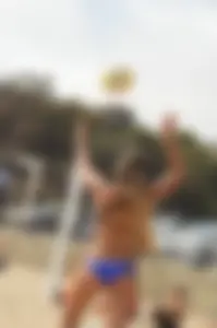 Sexy beach volleyball girl in sport bra top with pokies and blue bikini bottom