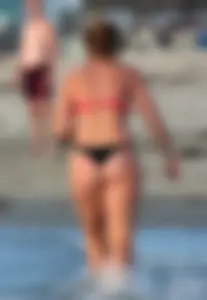 Thick white girls ass in a black thong bikini at the beach