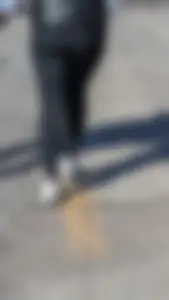 A beautiful little brunette walking in the park. tight black leggings