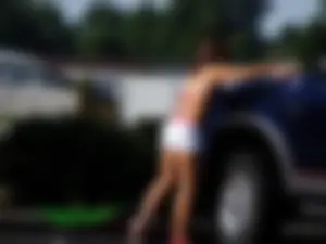 Group of cute girls at a car wash in bikinis and shorts