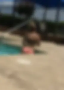 Blonde at the pool and laying out in peach and black bikini combo