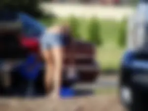Group of cute girls at a car wash in bikinis and shorts
