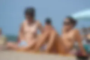 2 topless girls at the beach in thongs