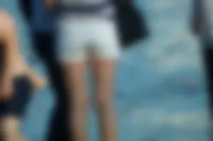 Hot Tanned Legs in White Denim Shorts on the Beach Closeup Photos