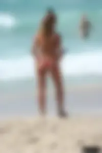 Topless girl in a tiny thong on the beach playing paddle ball
