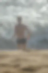 Blonde lady on the beach in bikini top and spandex shorts with a nice gap