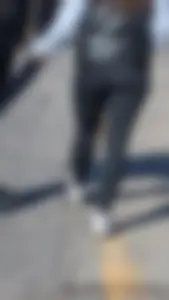 A beautiful little brunette walking in the park. tight black leggings