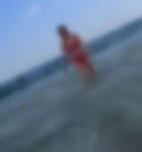 Sexy girl at the beach in a red thong bikini with nice tits and ass