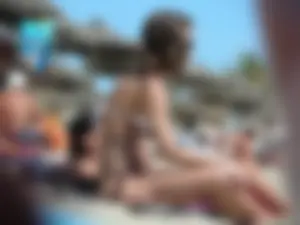 Tattooed babe at the beach with a nice round ass in little thong bikini