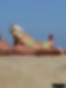 Hot blonde on the beach topless and in a white thong bikini
