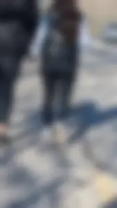 A beautiful little brunette walking in the park. tight black leggings