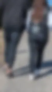 A beautiful little brunette walking in the park. tight black leggings