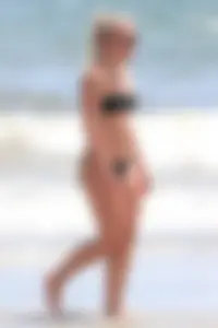 Beach blonde in the water in black bikini with a nice ass and small boobs