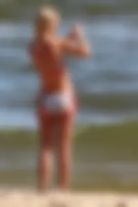 Beautiful skinny blonde babe with cute ass in bikini on the beach