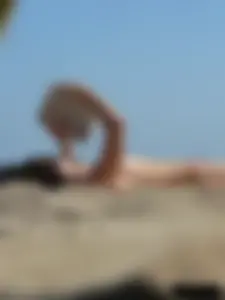 Topless beach milf looking sexy in a tiny g-string bikini